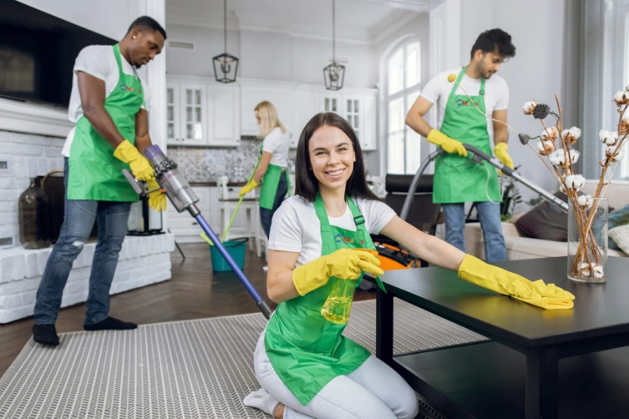 Professional apartment cleaning team in Fort Myers wiping tables, vacuuming floors, and cleaning kitchen in a modern home.