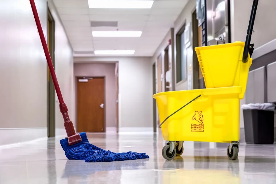 Professional house cleaning Fort Myers mop and yellow bucket on shiny corridor floor