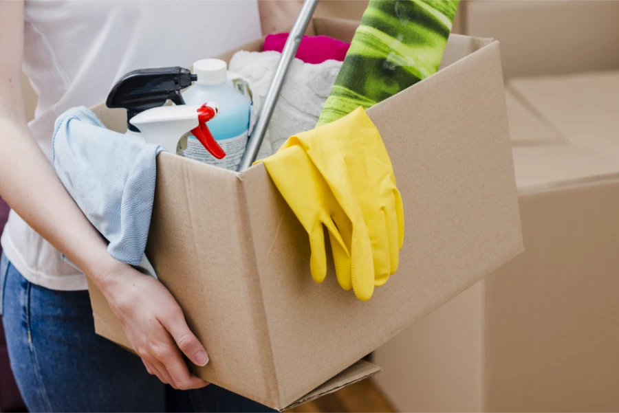 Move In Move Out Cleaning Fort Myers professional carrying cardboard box
filled with spray bottles, yellow rubber gloves and microfiber cloths
ready to clean a home